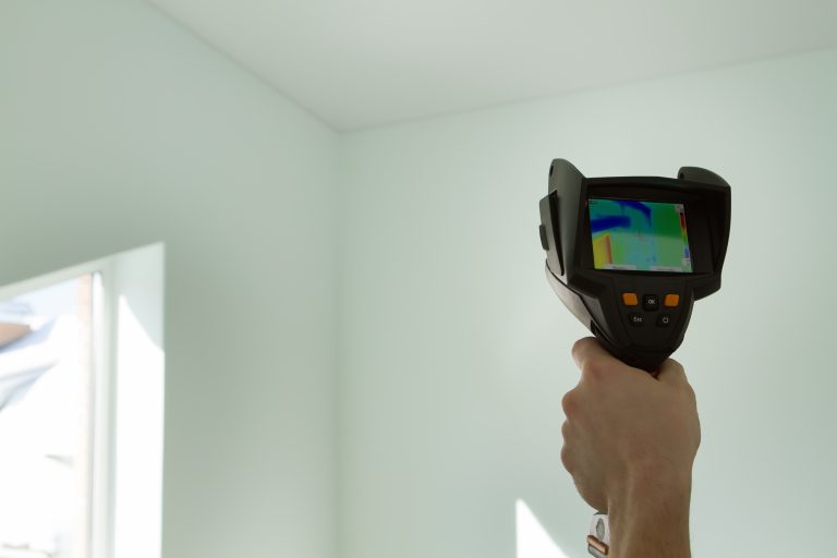 Man's,Hand,Holds,A,Thermal,Imager,-,Checks,The,Walls